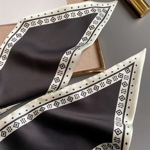 Detail eines gewellten Seidenschals mit schwarz-weißen geometrischen Randmustern