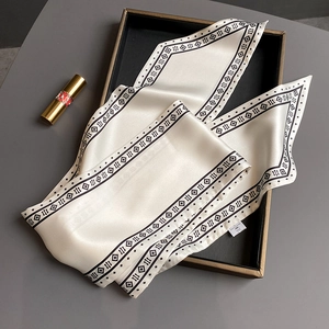 Detail eines seidigen Halstuchs mit geometrischen Mustern in einer Luxus-Box
