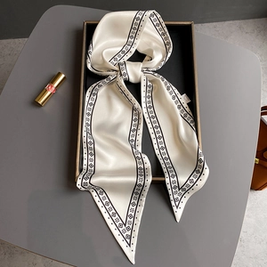 Nahaufnahme eines Seidenschals mit geometrischem Rautenmuster in einer edlen Geschenkbox