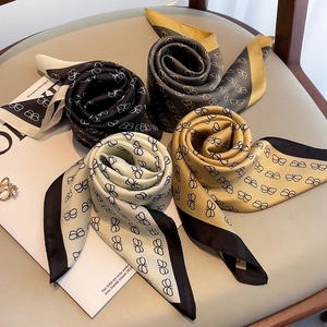 Detailed view of four colorful printed silk scarves with butterfly patterns on a chair
