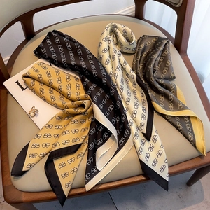 Detail of printed silk scarves in multiple colors elegantly arranged on a chair