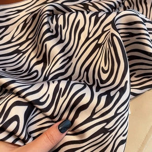 Macro shot of zebra pattern satin scarf showing silky texture and soft folds