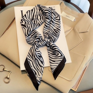 Elegant zebra pattern square silk scarf styled on a chic beige blazer and magazine
