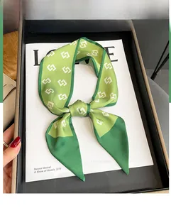 Detail of green silk scarf with geometric interlocking pattern on a magazine background