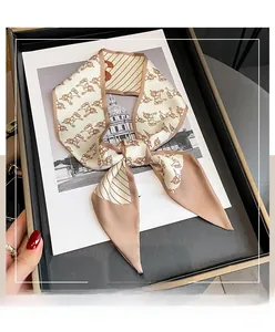 Macro detail of vintage horse print silk scarf with brown edges in a luxury gift box