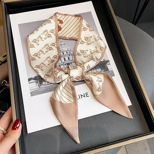 Elegant beige and brown silk scarf with horse prints tied in a bow in a gift box