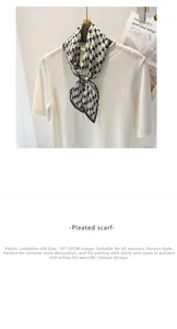Détail d'un foulard en soie plissé avec motif pied-de-poule noir et blanc