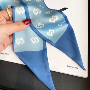 Detail of blue and white geometric silk scarf with intricate interlocking patterns