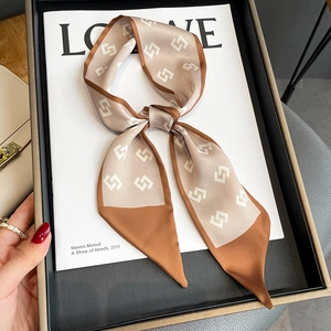 Fashionable geometric silk scarf tied in a bow on a luxury display tray