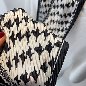 Gros plan d'un foulard en soie plissé à motif pied-de-poule noir et blanc chic