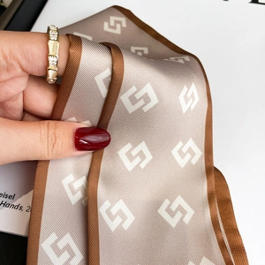 Detail of elegant geometric print narrow silk scarf with high-density twill texture