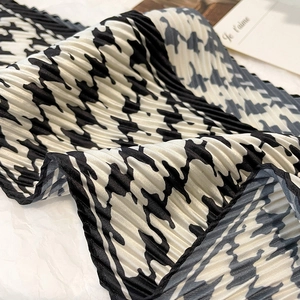 Gros plan d'un foulard plissé en soie avec motif pied-de-poule noir et blanc chic