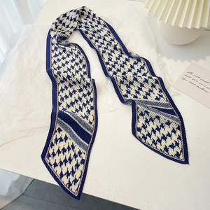 Gros plan sur l'écharpe en soie à motif pied-de-poule bleu et texture plissée