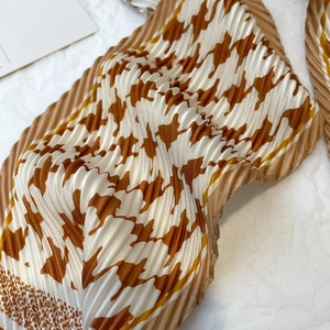 Détail d'un foulard plissé en soie avec motif pied-de-poule et texture
