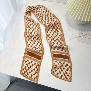 Détail d'un foulard en soie plissé à motif pied-de-poule et pointes en biseau