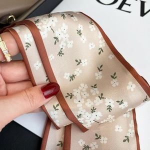 Detail showing high-quality floral print texture on a slim beige neck scarf for handbags