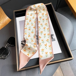 Détail du motif floral tulipe orange et des bords roses sur le foulard twilly en soie