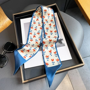 Détail d'un foulard en soie à fleurs avec lunettes de soleil sur un magazine