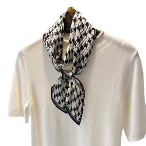 Élégant foulard plissé en soie à motif pied-de-poule noir et blanc sur un haut en tricot