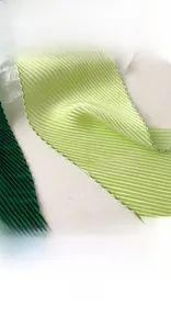 Detailed view of careful edge sealing on pleated gradient silk scarf in green