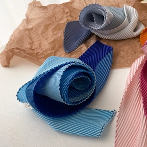 Detail of gradient pleated skinny scarf showing exquisite wavy edges and silk-like texture