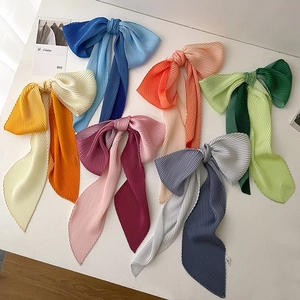 Macro detail of pleated gradient scarves in vibrant colors with jagged edge textures