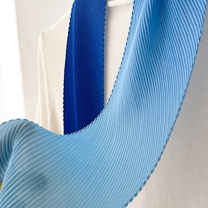 Detailed view of ombre blue pleated scarf featuring fine accordion folds and wavy edges