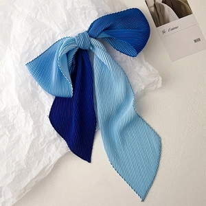 Close-up of pleated two-tone blue silk scarf with vertical textures and stitched edges
