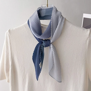 Detailed view of blue gradient pleated neck scarf styled on a white knitted sweater