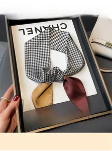 Detail of houndstooth silk scarf with tricolor patchwork and metal ring accessory