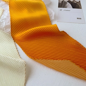 Detailed view of pleated gradient silk scarf with high-density accordion texture