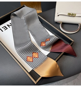 Detail of houndstooth twilly scarf with burgundy tips and CC motifs on display