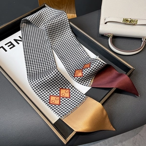 Detailed view of houndstooth silk twilly scarf with C.C logo and burgundy accent