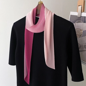 Detail of pleated long silk scarf with pink gradient texture on mannequin stand
