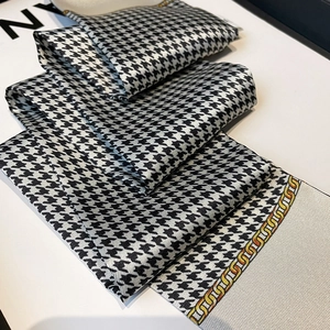 Detailed view of houndstooth silk scarf featuring elegant gold chain edge patterns