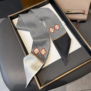 Detail of houndstooth silk scarf with red diamond patterns and pointed edges