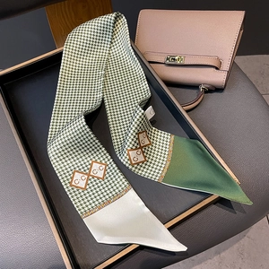 Detail of green and white houndstooth twilly scarf with CC print on a luxury handbag