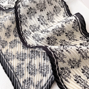 Vue détaillée d'une écharpe plissée noire et blanche avec motif cachemire élégant