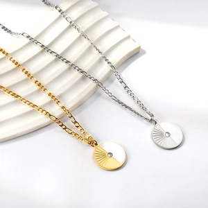 Golden and silver Figaro chain necklaces with sunburst shell round pendants on display