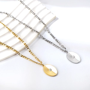 Detail of gold and silver sunburst oval pendants with inset crystals on Figaro chains