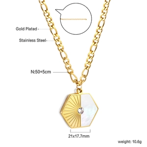 Macro view of geometric gold pendant featuring white shell inlay and zircon center