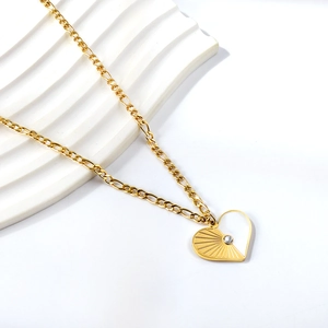 Macro shot of 18K gold plated asymmetric heart pendant with diamond on Figaro chain
