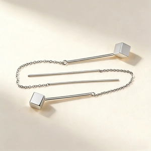 Detail view of minimalist silver geometric earrings with cube pendant and long tassel chains