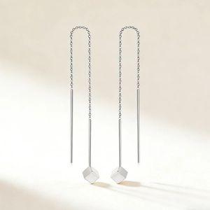 Detailed view of silver minimalist tassel chain earrings with geometric cube pendant