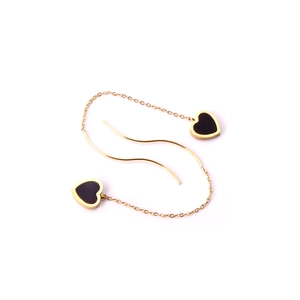 Macro detail of gold-plated long threader earrings with black heart-shaped pendants