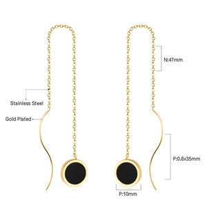 Detail view of gold-plated stainless steel tassel earrings with black shell heart pendants