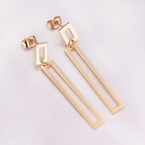 Close-up of golden geometric earrings featuring square and rectangular frames in minimalist style
