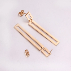 Flat lay of gold geometric long dangle earrings with hollow rectangular and square design