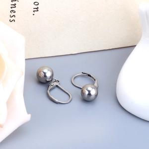 Gros plan de boucles d'oreilles boules en argent poli avec fermoir dormeuse