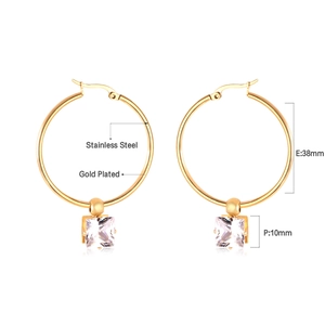 Vue détaillée de créoles en acier doré avec pendentifs en pierre de zircon carrée